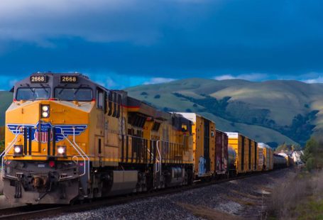 Train - yellow and black train near mountain