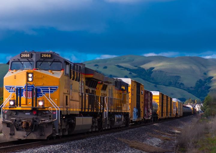 Train - yellow and black train near mountain