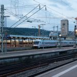 Train Ticket - a train on a train track next to a train station