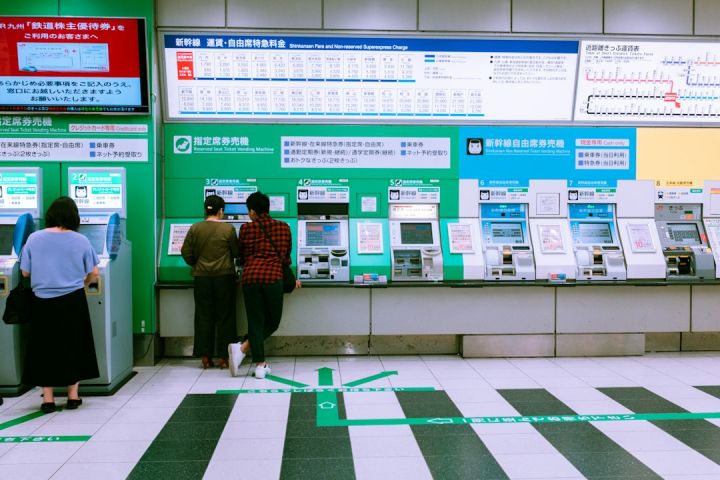 Train Ticket - man in black jacket standing near green and white wall