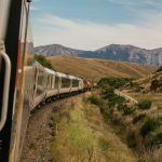 Train Ticket - white train with the distance of mountain during daytime