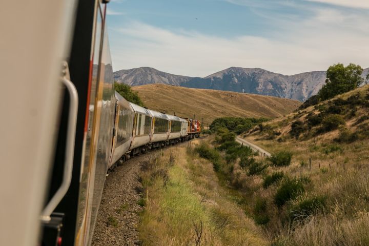 Train Ticket - white train with the distance of mountain during daytime