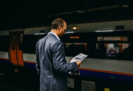 Train Ticket - man holding newspaper standing on train station