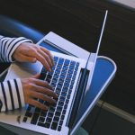 Train Seat - Person in Black and White Striped Long Sleeve Shirt Using Macbook Pro