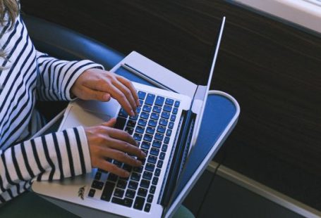 Train Seat - Person in Black and White Striped Long Sleeve Shirt Using Macbook Pro