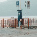 Lost Tickets - Child Standing on Gray Stone Pavement Beside a Parking Ticket Booth