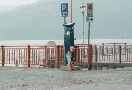 Lost Tickets - Child Standing on Gray Stone Pavement Beside a Parking Ticket Booth