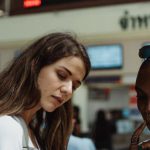 Train Timetables - Women Using a Smartphone on a Train Station