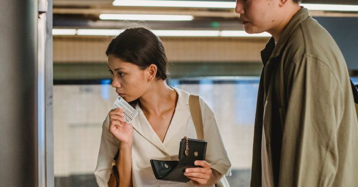 Train Tickets - Focused Asian couple buying ticket on station