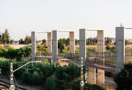 Scenic Train Routes - From above of railway tracks running between lush green plants under cloudless sky