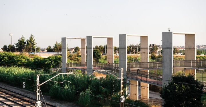 Scenic Train Routes - From above of railway tracks running between lush green plants under cloudless sky