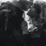 Romantic Train Getaway - Grayscale Photo of Man Kissing Woman's Nose While Standing Inside a Train
