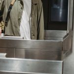 Train Ticket - Crop unrecognizable male passenger in casual clothes with backpack inserting ticket in entrance machine of automated gate while entering modern subway station
